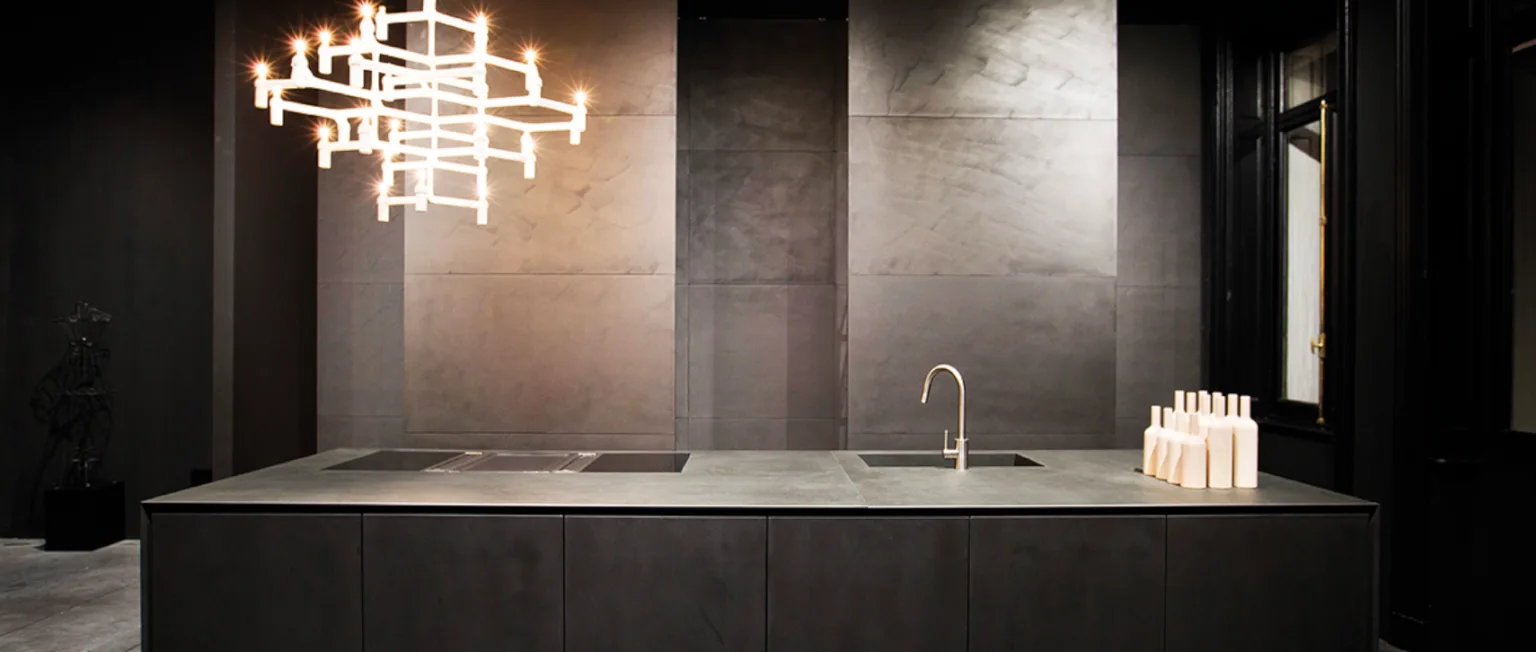 Cocina con isla y superficies Calce Nero, imagen del catálogo de Decorstone.